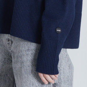 Close up of sleeve of navy cashmere sweater