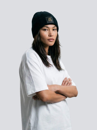 Woman wearing a black beanie with text I AM YOUR SISTER