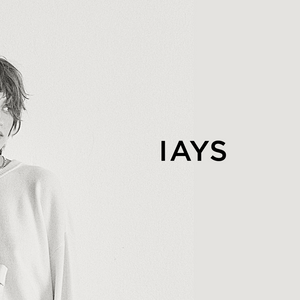 Two people wearing white sweaters with 'IAYS' logo on a light gray background